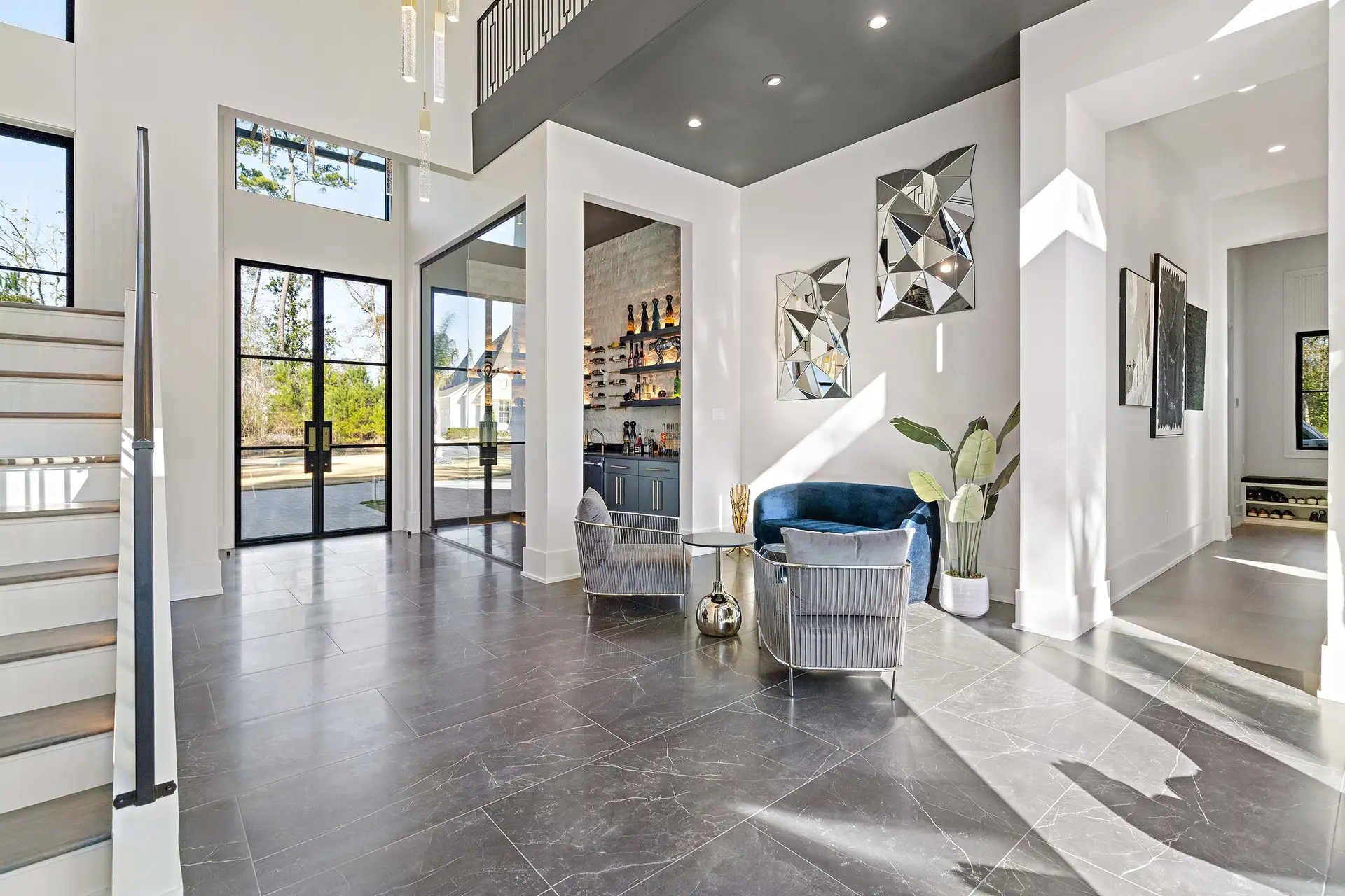 Modern luxury home interior with tall ceilings and large windows by Troyer Builders