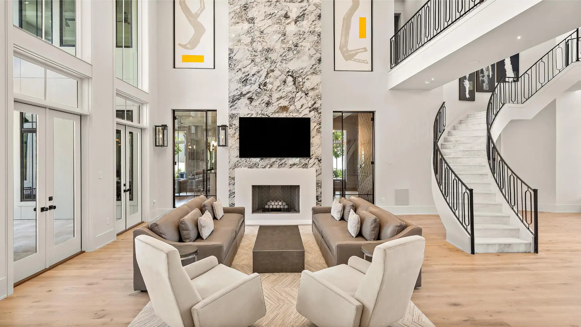 Custom luxury living room with curved staircase and fireplace in a Troyer Builders design-build home
