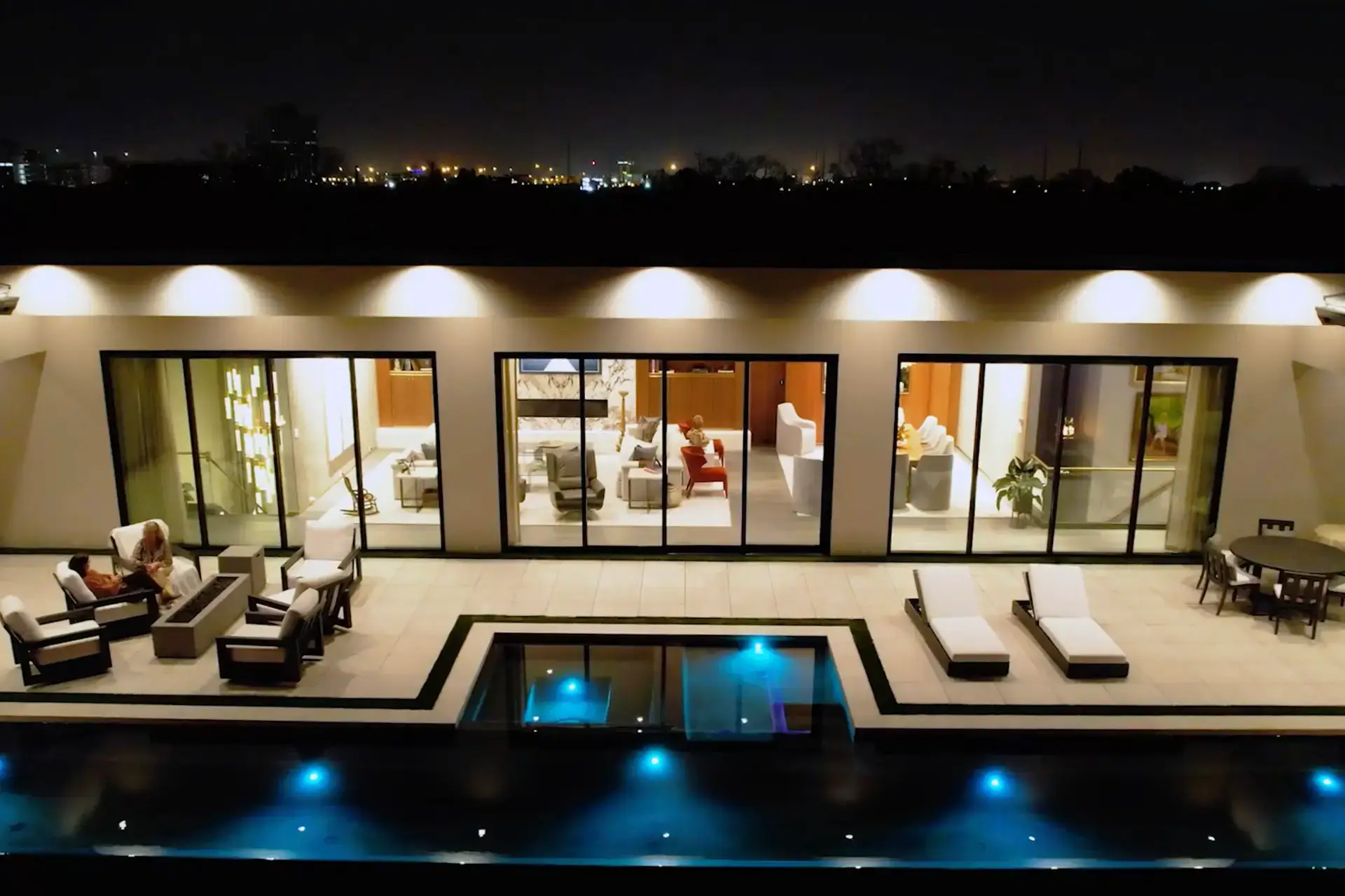 Custom smart luxury home with integrated lighting and pool at night by Troyer Builders