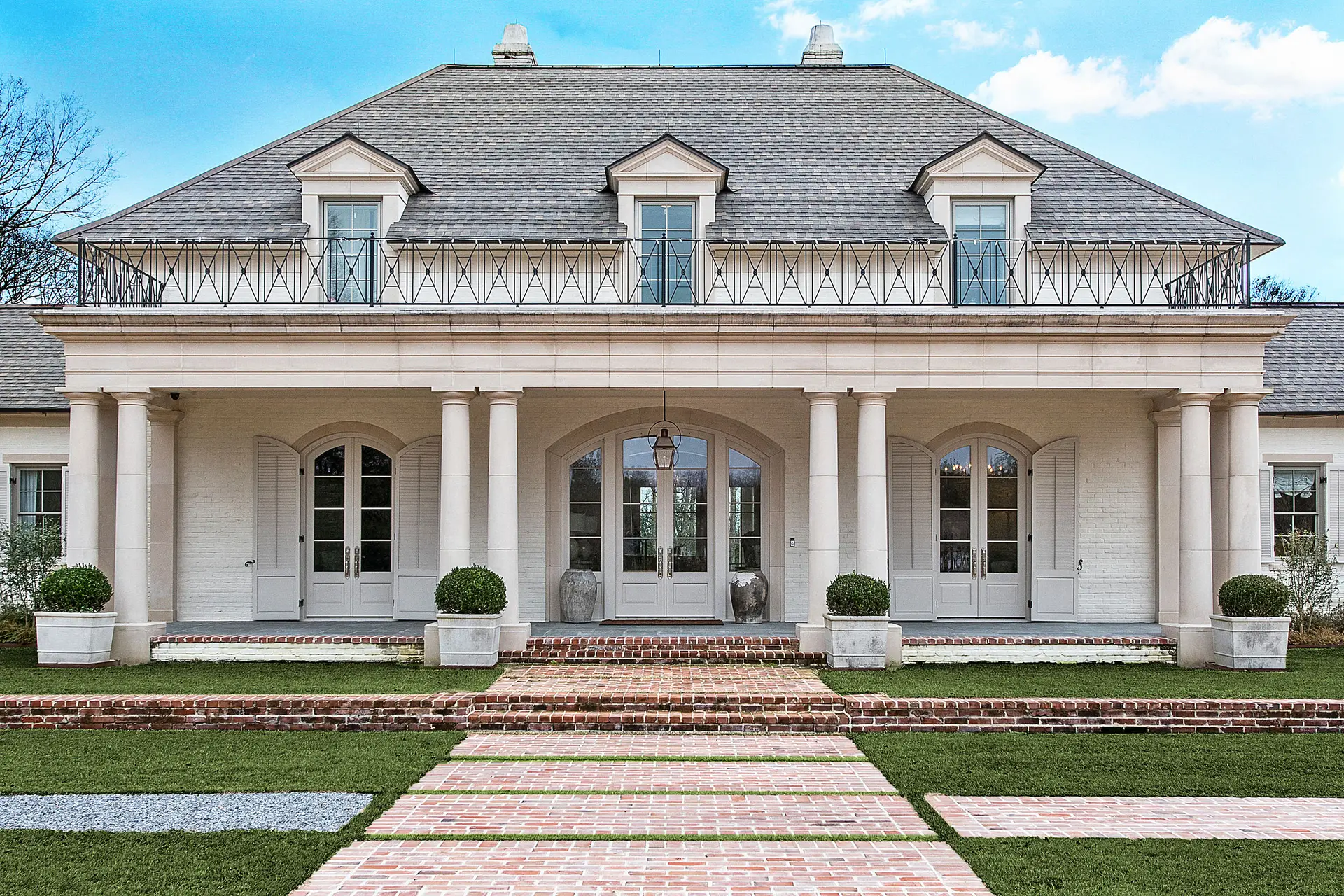 Elevated traditional luxury home with columned porch built for Louisiana storms by Troyer Builders